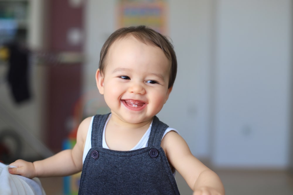 bambino sorride e mostra i primi denti da latte